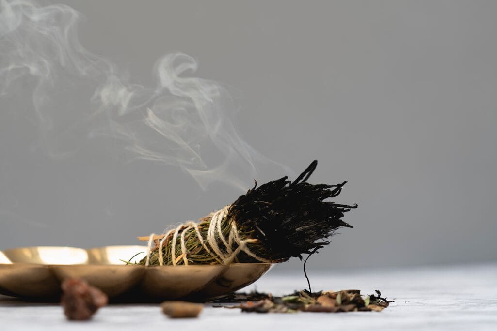 Herb bundle burning as incense for love ritual cleansing